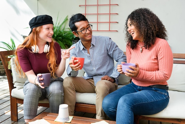 Foto alegres amigos multiétnicos bebiendo café