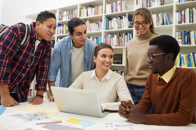 Alegres estudiantes que estudian en la biblioteca