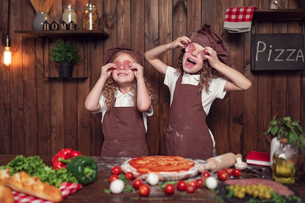 Alegres garotas se divertindo com salsicha na cozinha