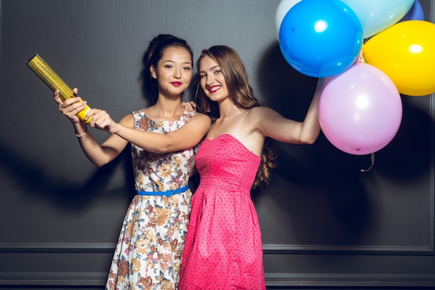 Foto alegres hermosas mujeres jóvenes que tienen fiesta