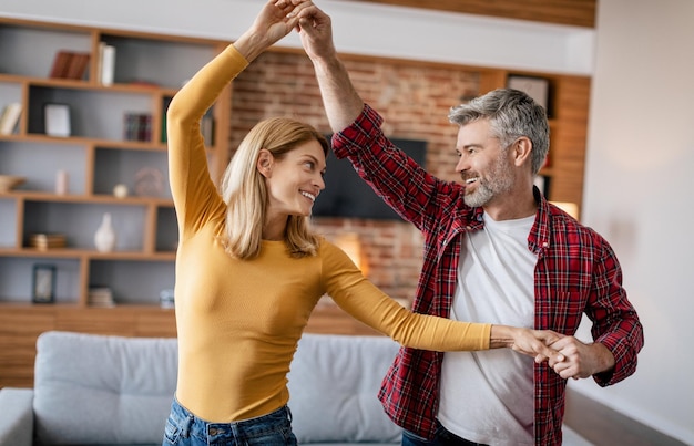 Alegres mulheres e homens europeus maduros relaxando aproveitam o tempo livre dançando juntos se divertem