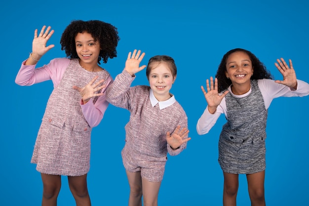 Alegres namoradas internacionais em dança casual, divirtam-se, aproveitem o tempo livre isolado em azul