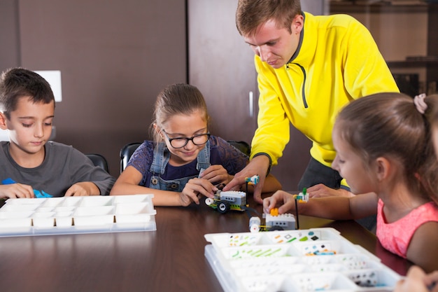 Alegres niños sonrientes están construyendo un constructor.