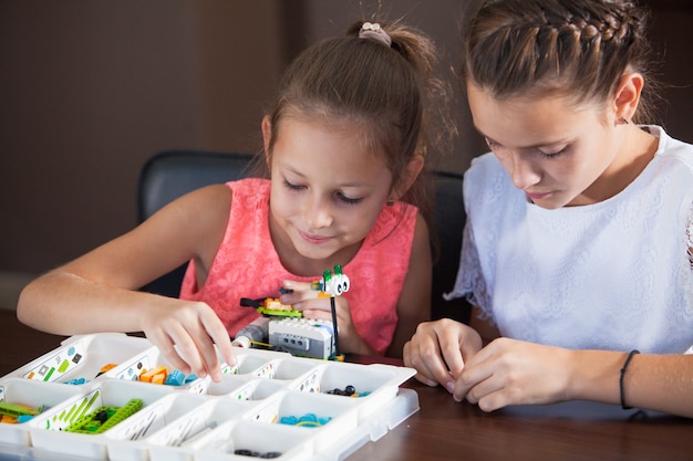 Alegres niños sonrientes están construyendo un constructor.