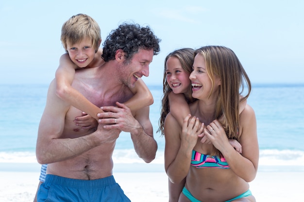 Alegres padres con hijos en la playa