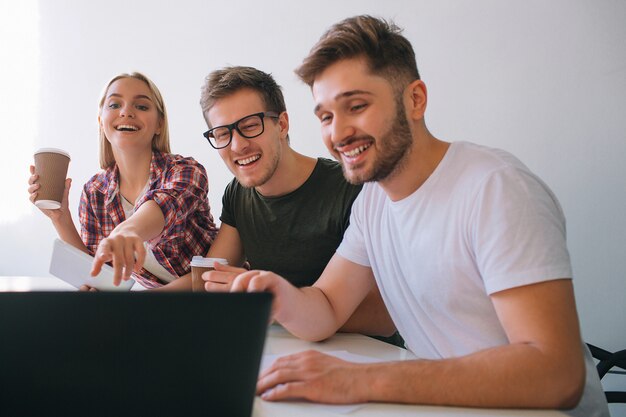 Alegres y positivos jóvenes compañeros de trabajo riendo