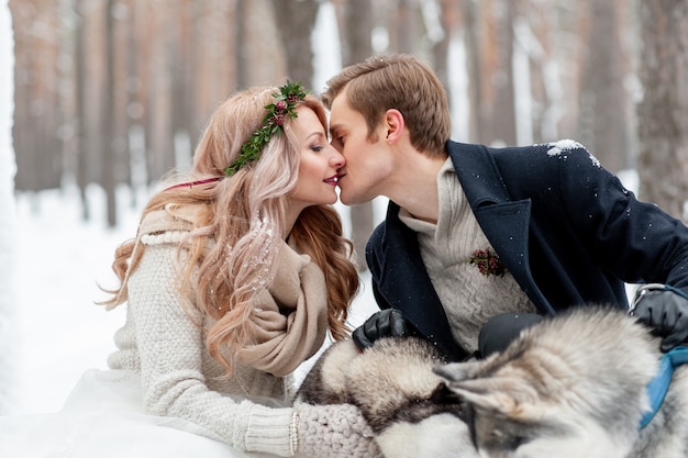 Alegres recién casados se besan en el fondo de husky. Boda de invierno Copia espacio