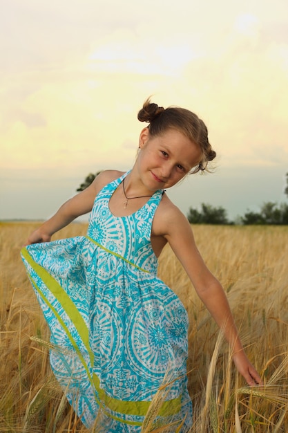 Alegrías de niña en el campo de trigo