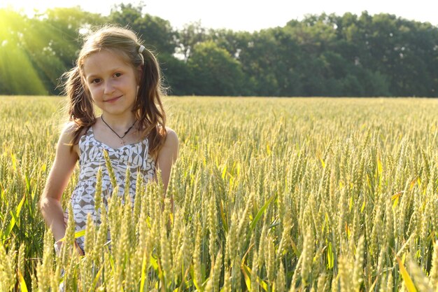 Alegrías de niña en el campo de trigo