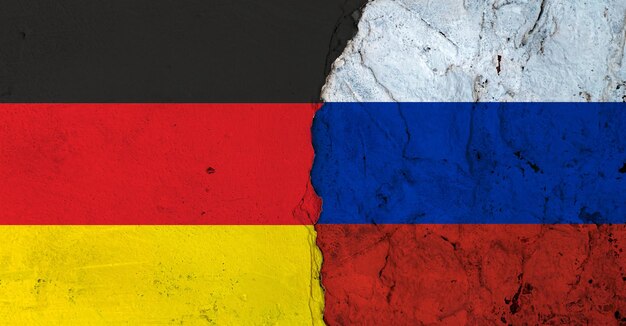 Alemanha e Rússia em conflito Bandeiras de países alemães e russos em paredes quebradas
