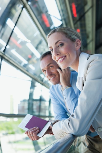 Alemania LeipzigHalle Airport empresario y empresaria hombre sonriente a través de teléfono móvil