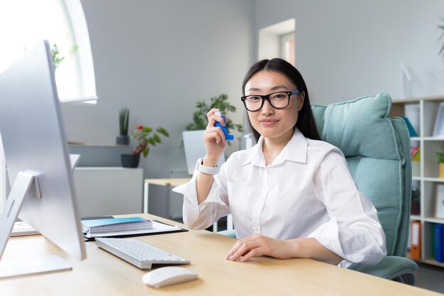 Alergia sintiéndose mal en el lugar de trabajo una joven asiática con anteojos sostiene un inhalador en la mano