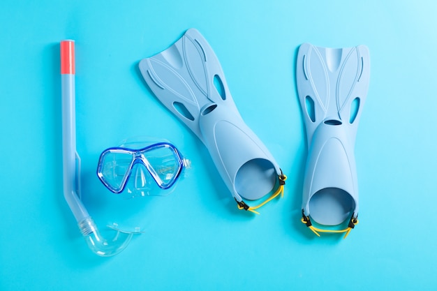Aletas, snorkel y máscara de buceo en mesa azul