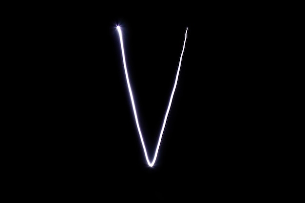 Alfabeto feito de luz neon em um fundo preto Vista superior isolada letra v