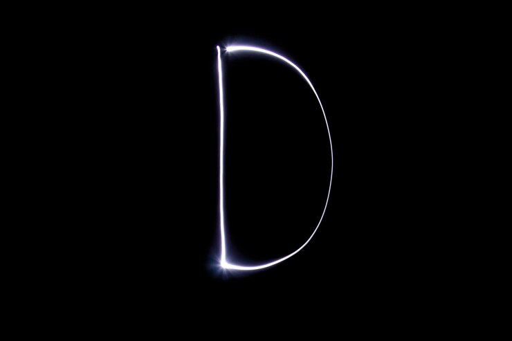 Foto alfabeto hecho de luz de neón sobre un fondo negro vista superior aislada letra d