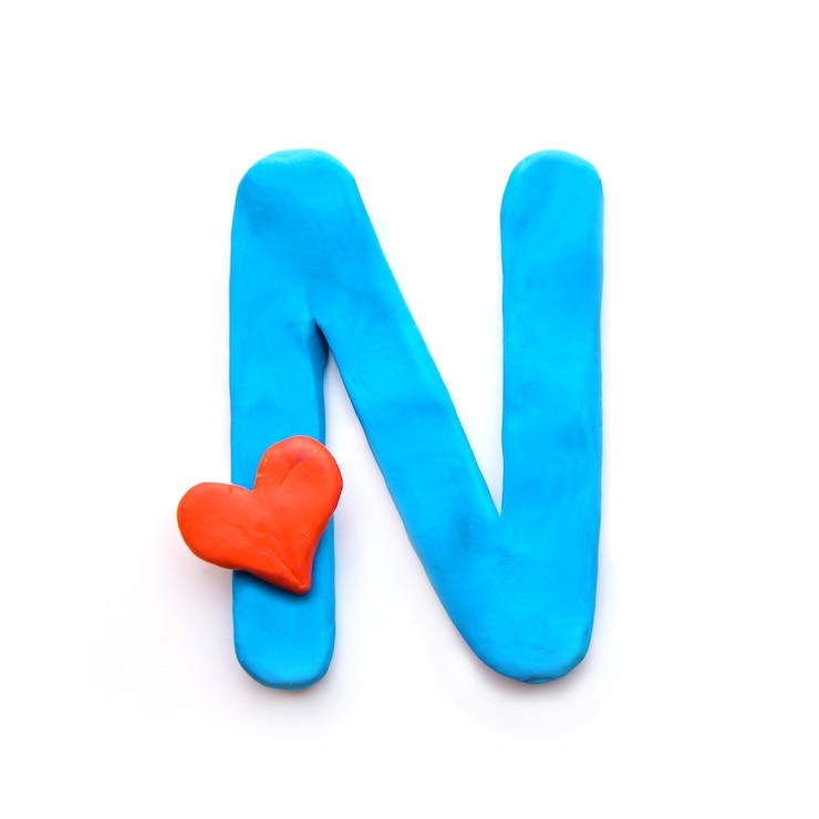 Foto alfabeto inglés de plastilina azul letra n con corazón rojo que significa amor