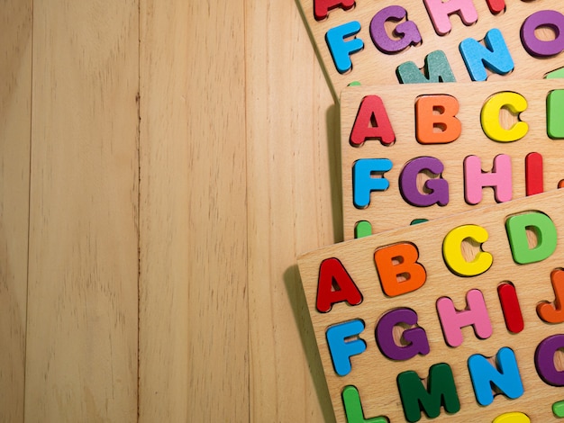 El alfabeto de madera multicolor en la mesa para la educación o el concepto de niño