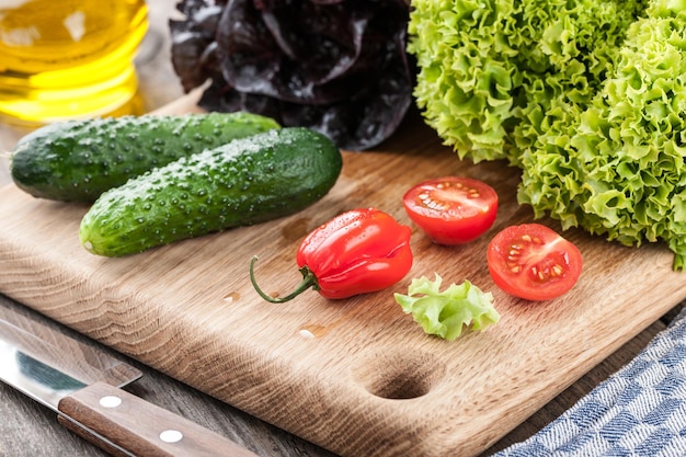 Alface fresca e outros vegetais na tábua