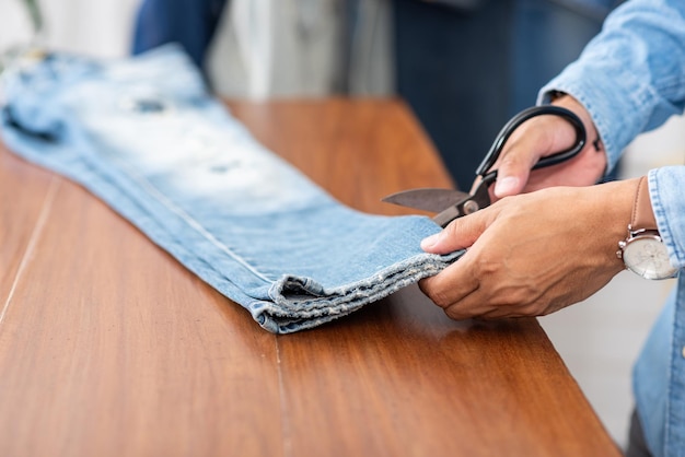 Foto alfaiate a trabalhar com calças jeans