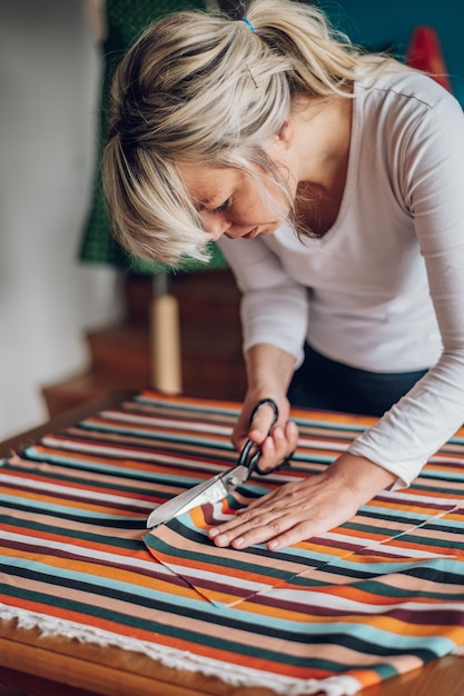 Foto alfaiate de mulher trabalhando em casa e costurando roupas bonitas