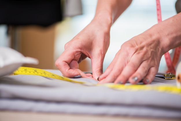 Alfaiate mãos trabalhando na roupa nova