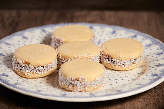 Alfajores de cornflow deliciosos cookies argentinos com close-up de creme de doce de leite isolado. macaroons de baunilha branca em fundo branco. sobremesa delicada francesa no café da manhã.