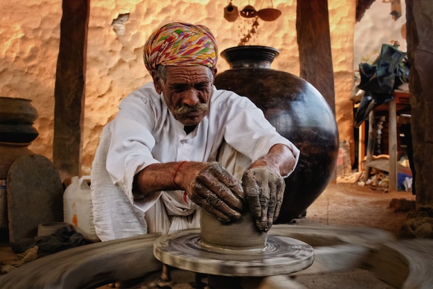 Alfarero indio en el trabajo. trabajo artesanal de shilpagram, udaipur, rajasthan, india