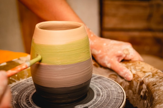 Alfarero trabajando en torno de alfarero con arcilla Proceso de elaboración de vajillas de cerámica en taller de cerámica Artesanía y concepto de arte