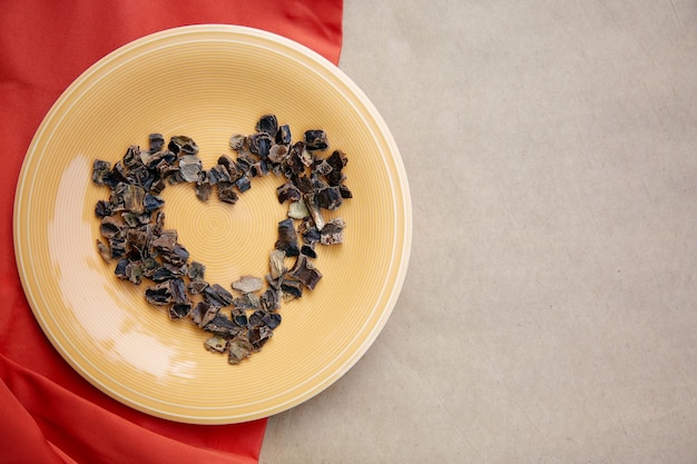 Alfarroba em forma de coração símbolo de produto natural alternativo de café no prato Antioxidantes orgânicos de cafeína à base de plantas Vista superior cópia espaço Foto de alta qualidade