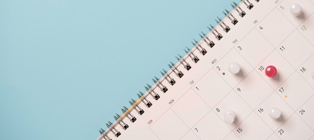 Alfiler rojo y blanco en el calendario para reuniones de negocios y concepto de planificación de viajes