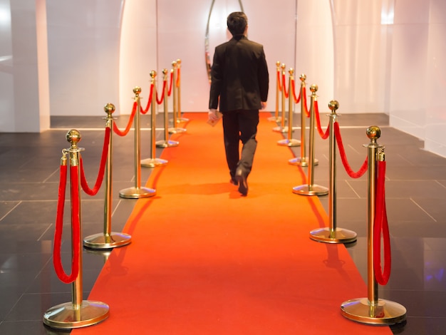 Alfombra roja entre las barreras de la cuerda en la fiesta de éxito. Enfoque seleccionado en las barreras de cuerda.