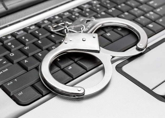 Algemas no teclado do laptop Conceito de crime cibernético