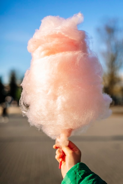 algodón de azúcar en la mano de un niño en un parque de verano comida dulce y azúcar