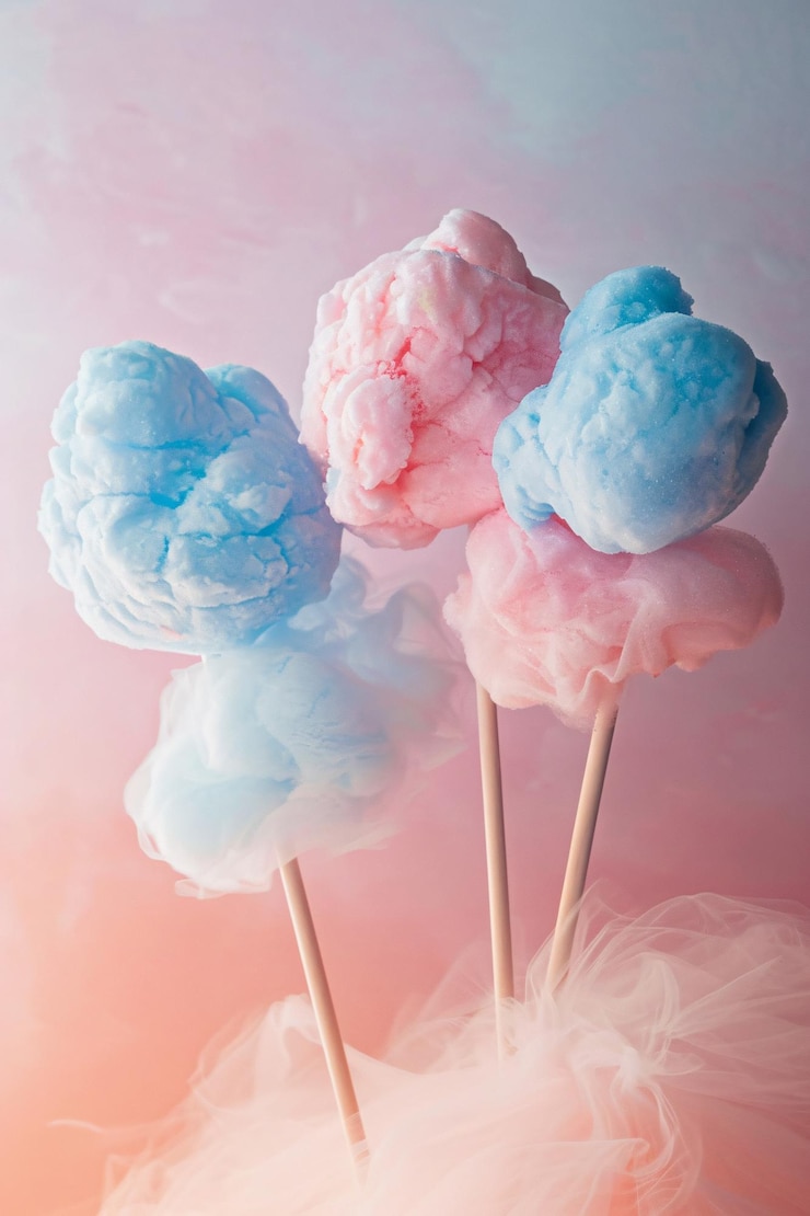 Algodón caramelo en palos de color rosa y azul con un fondo de colores vibrantes