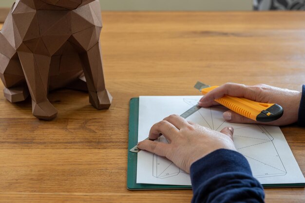 Alguém está fazendo uma escultura de cubo com papel linear e faca DIY