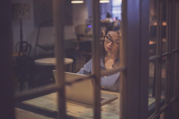 Alguém está olhando como a mulher está trabalhando com laptop