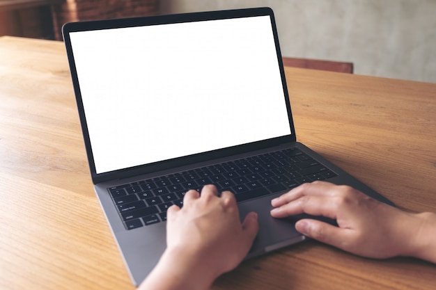 Alguém está usando o laptop na mesa de madeira