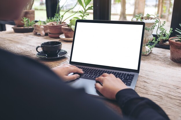 Alguien está escribiendo en una computadora portátil con una pantalla de escritorio blanca en blanco