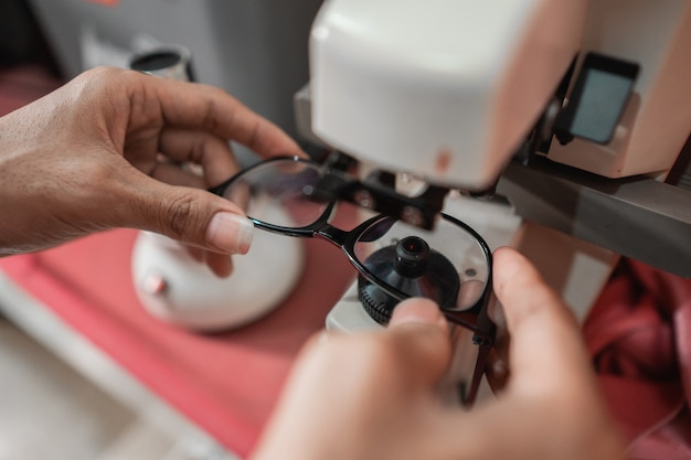 Alguien está revisando los anteojos de un paciente con un verificador de anteojos en una clínica oftalmológica