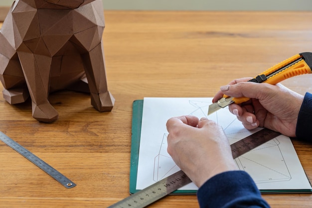 Foto alguien está haciendo una escultura de cubo con papel lineal y cuchillo diy