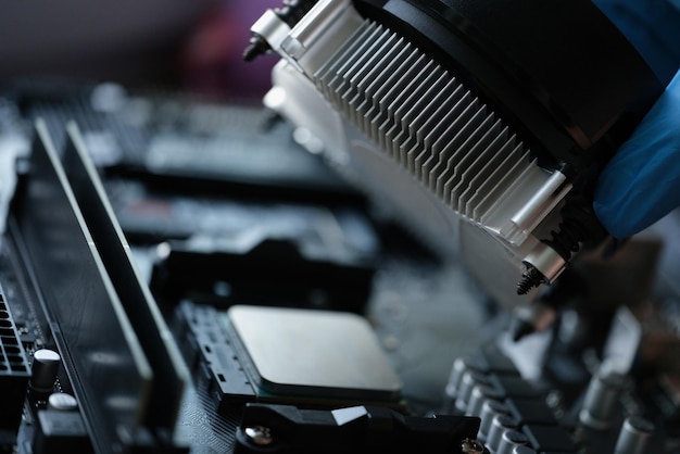 Alguien instala un ventilador más fresco con tubos de cobre en el guante estéril del procesador de la computadora para trabajar