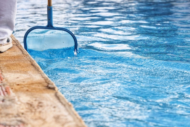 Foto alguien limpiando el lado de una piscina con un émbolo