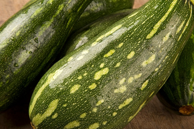 Algumas abobrinhas sobre uma superfície de madeira branca. Vegetais frescos.