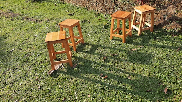 Algumas cadeiras de madeira no jardim verde com o sol da tarde brilhando 02