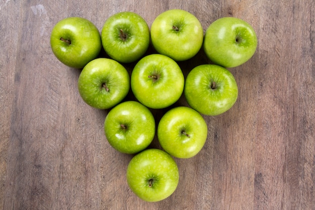 Algumas maçãs verdes em uma mesa de madeira. Frutas frescas