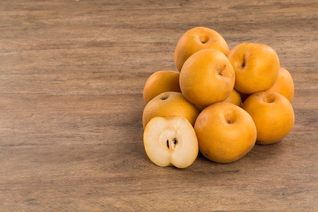 Algumas peras asiáticas sobre uma superfície de madeira. frutas frescas