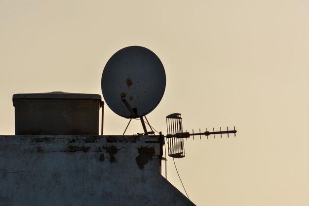 Algunas antenas silueteadas en la parte superior de un techo