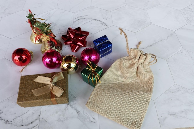 Foto algunas decoraciones navideñas como algunas campanas algunas bolas algunas cajas de regalos un lazo rojo y una bolsa