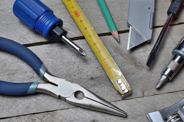 Foto algunas herramientas de reparación del hogar se encuentran sobre un fondo de madera. de cerca.