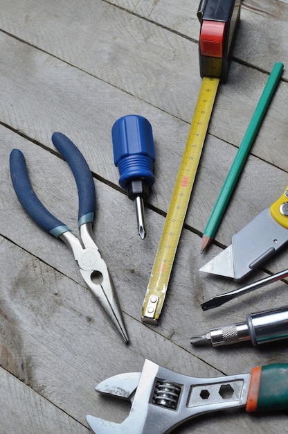 Algunas herramientas de reparación del hogar se encuentran sobre un fondo de madera. de cerca.